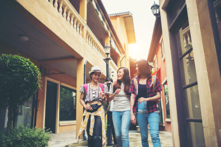 group of happy young friends having fun walking in urban street.
